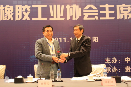 中国橡胶工业协会会长范仁德向8868登录入口董事长袁仲雪颁发荣誉奖牌 